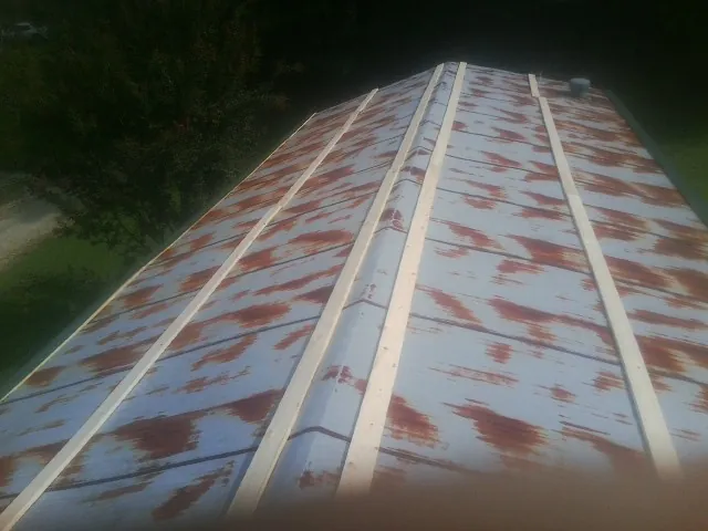 Rusted metal roof panels with new wood purlins before replacement — Storm Damage Roof Repair in Manning by Roofing Brothers